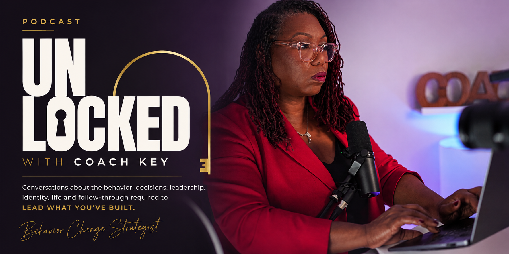 Unlocked with Coach Key — conversations about the behavior, decisions, leadership, identity, life and follow-through required to lead what you've built. Coach Key recording in a red blazer at her microphone.