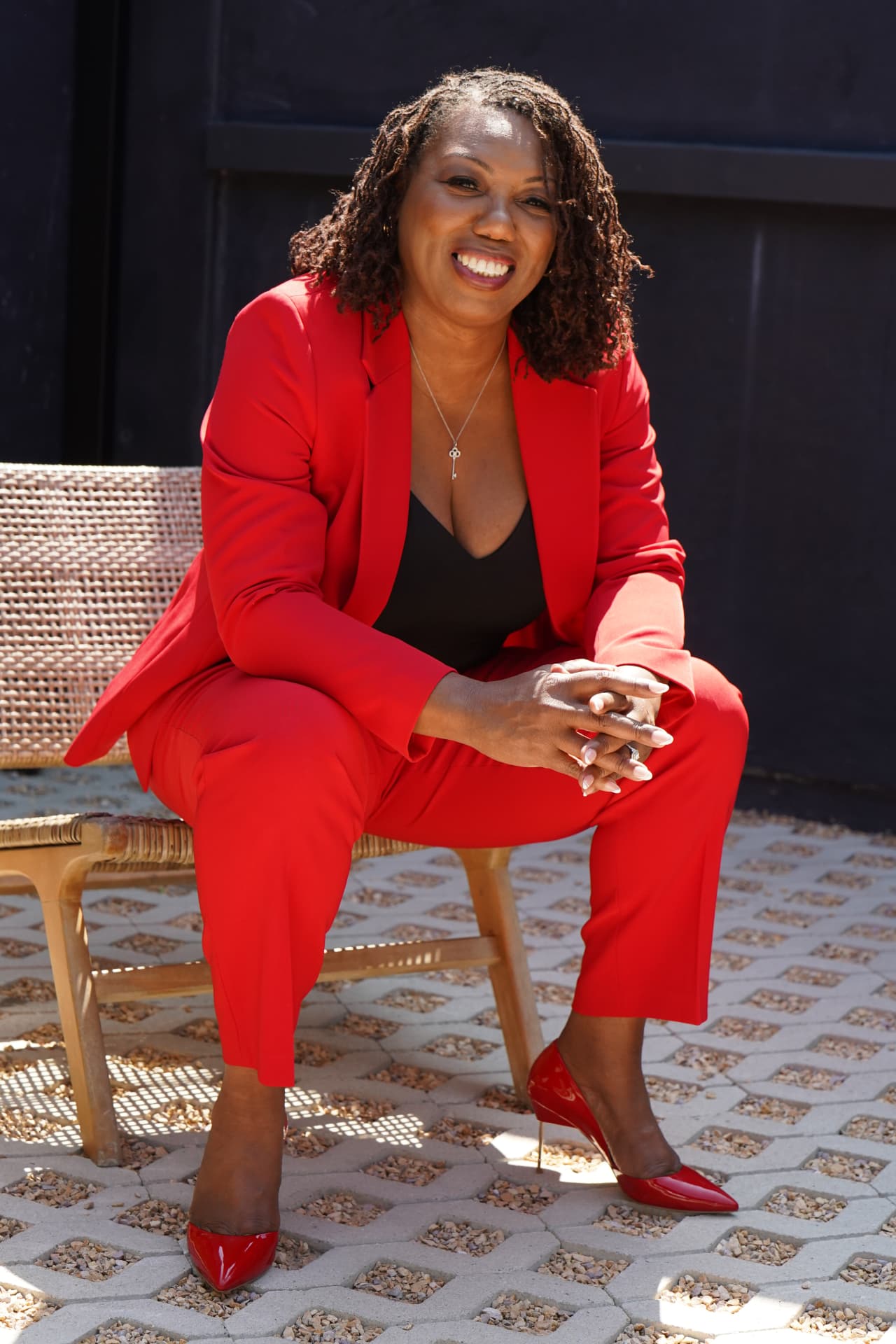 Coach Key, LaKeysha Cobbs-Hayes, seated in a red suit, smiling