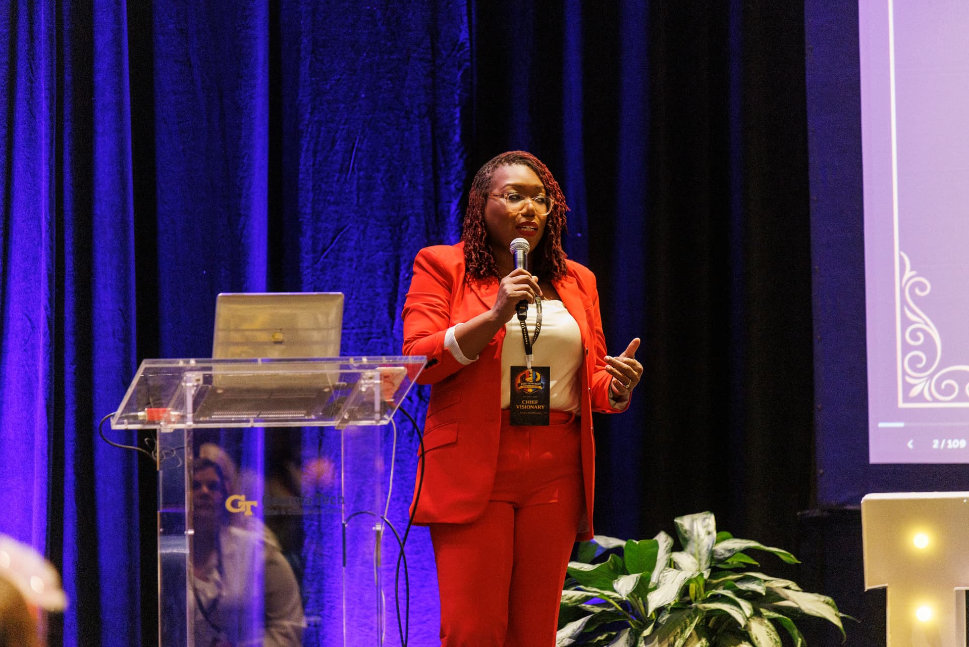 Coach Key, LaKeysha Cobbs-Hayes, speaking on stage into a handheld microphone